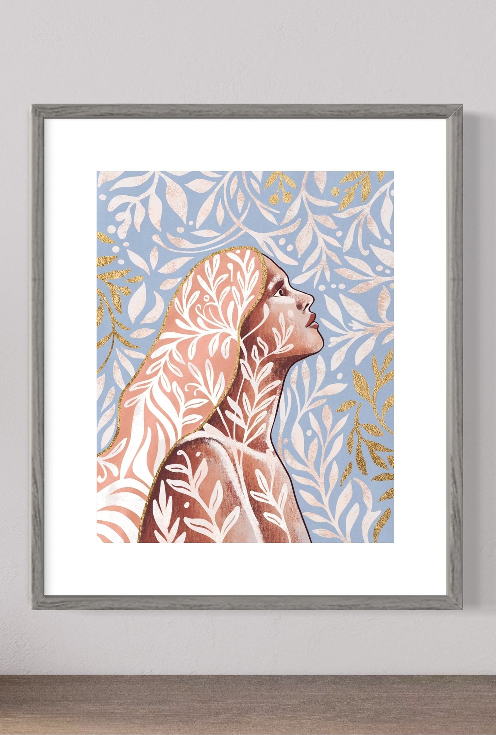 Framed artwork of a stylized face on a wall with decorative items below.